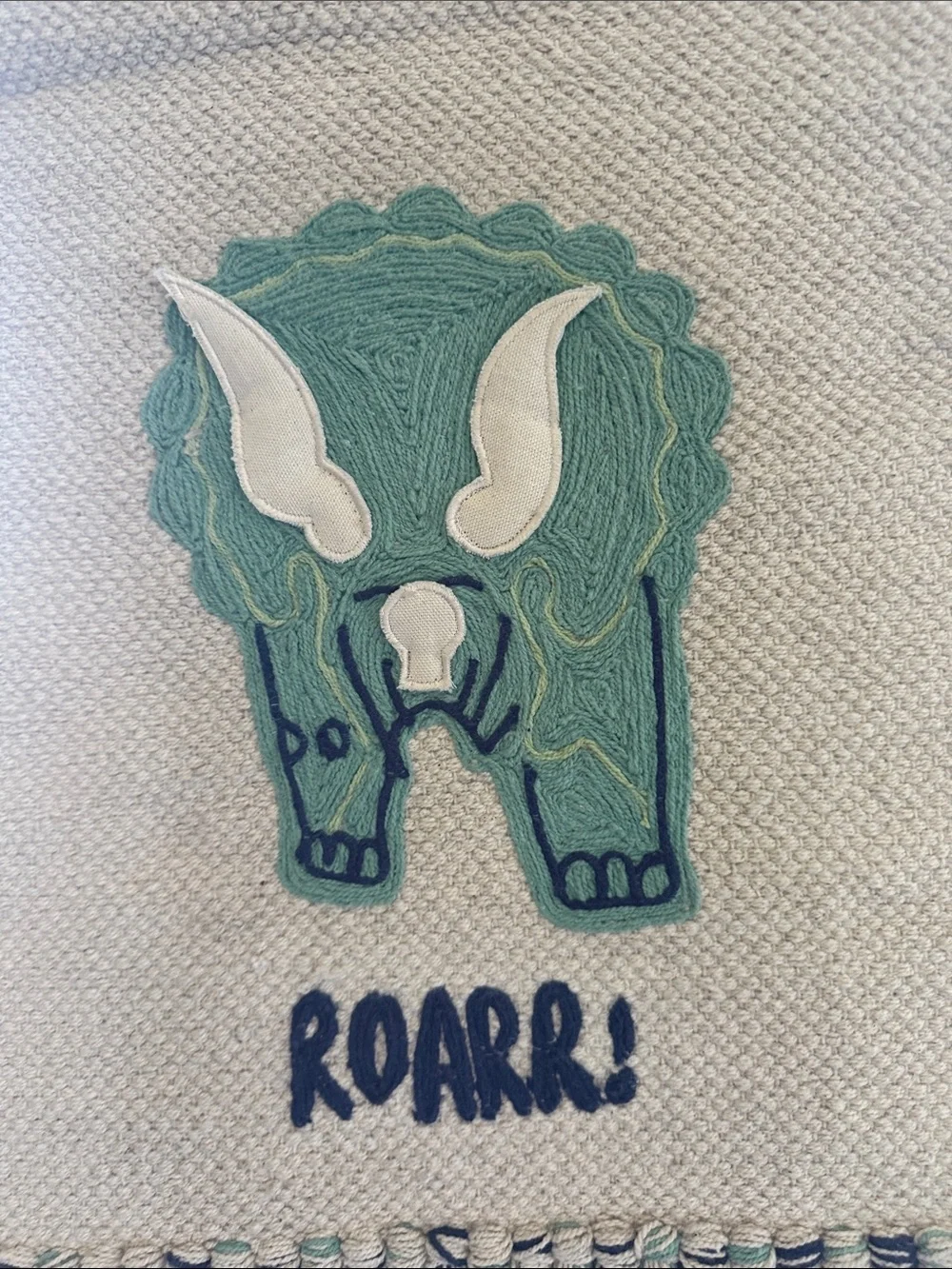 Handwoven Cream Wall Hanging with Green Triceratops Motif Nursery Design